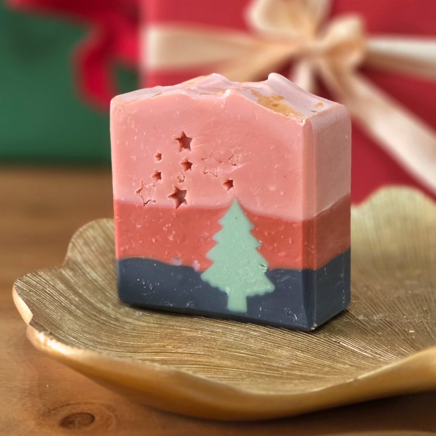 Сапун „Горско вълшебство“ SULLY Naturals с аромат на кипарис и тамян, сниман върху златен лист и коледни светлини.