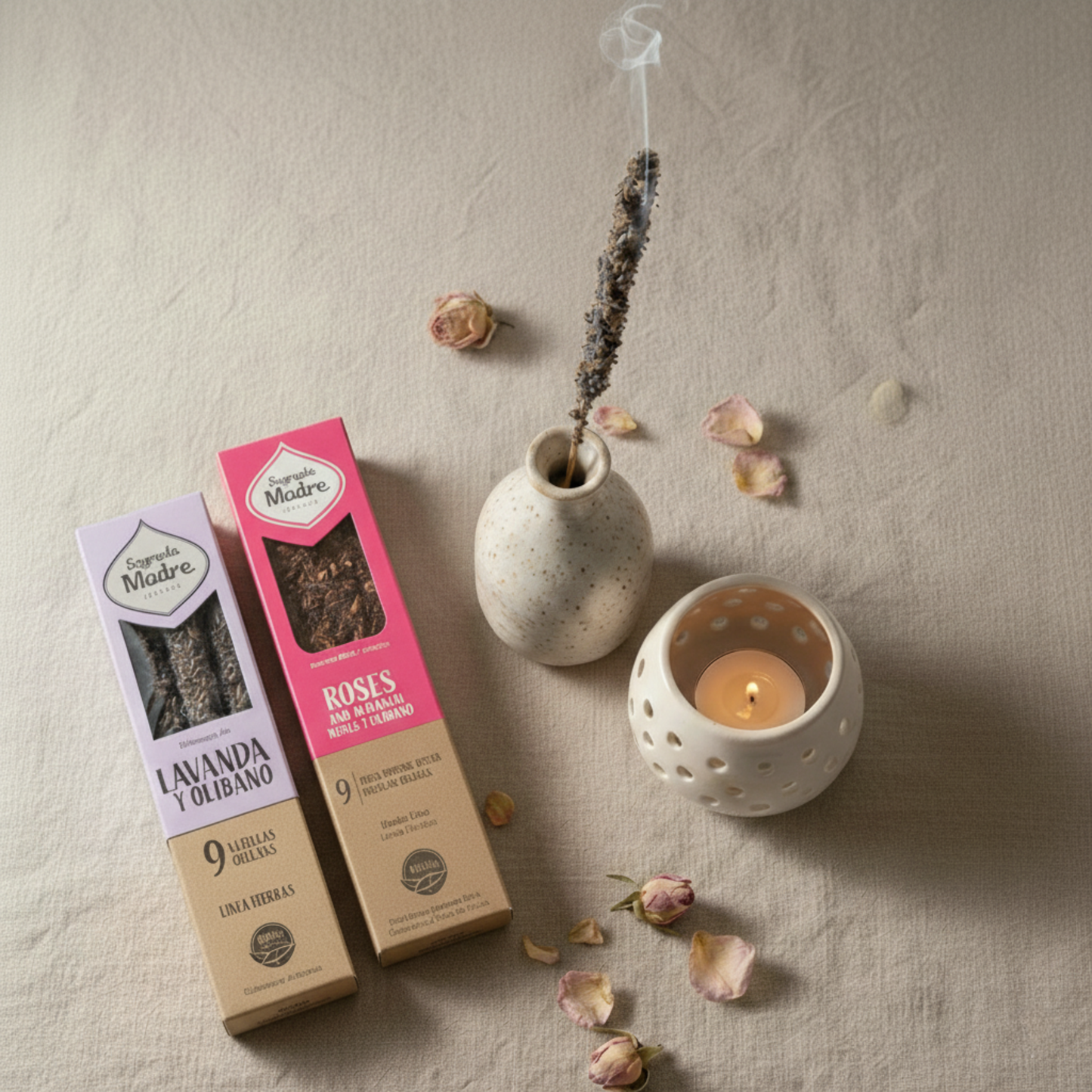 Две натурални ароматни пръчици Sagrada Madre - Roses и Lavender, поставени до запалена свещ в керамичен държач и сушени розови листенца.