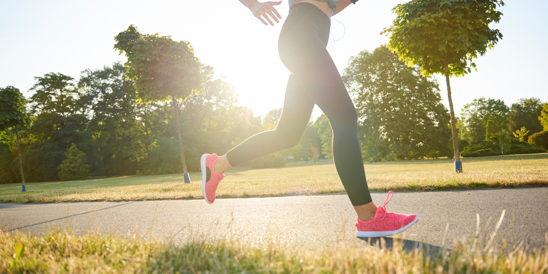 Жена бяга на открито в парк при пролетна слънчева светлина — активен начин на живот и грижа за кожата