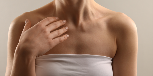 Жена докосва рамото си в баня, естествена текстура на кожата, мека светлина и усещане за сухота