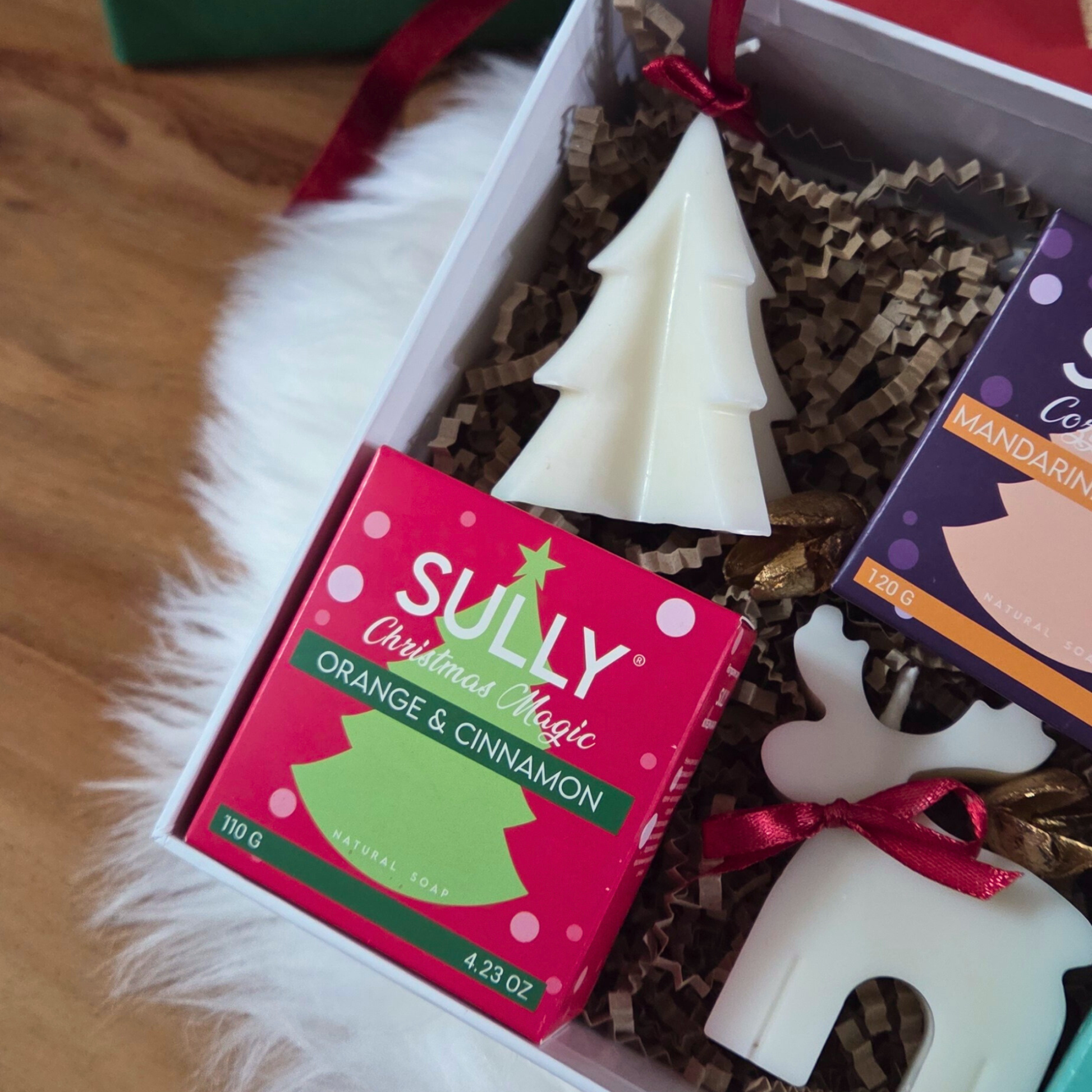 Празнична кутия с комплект „Ароматна Коледа“ – сапуни и свещи фигурки във формата на елхичка, еленче и ангелче.