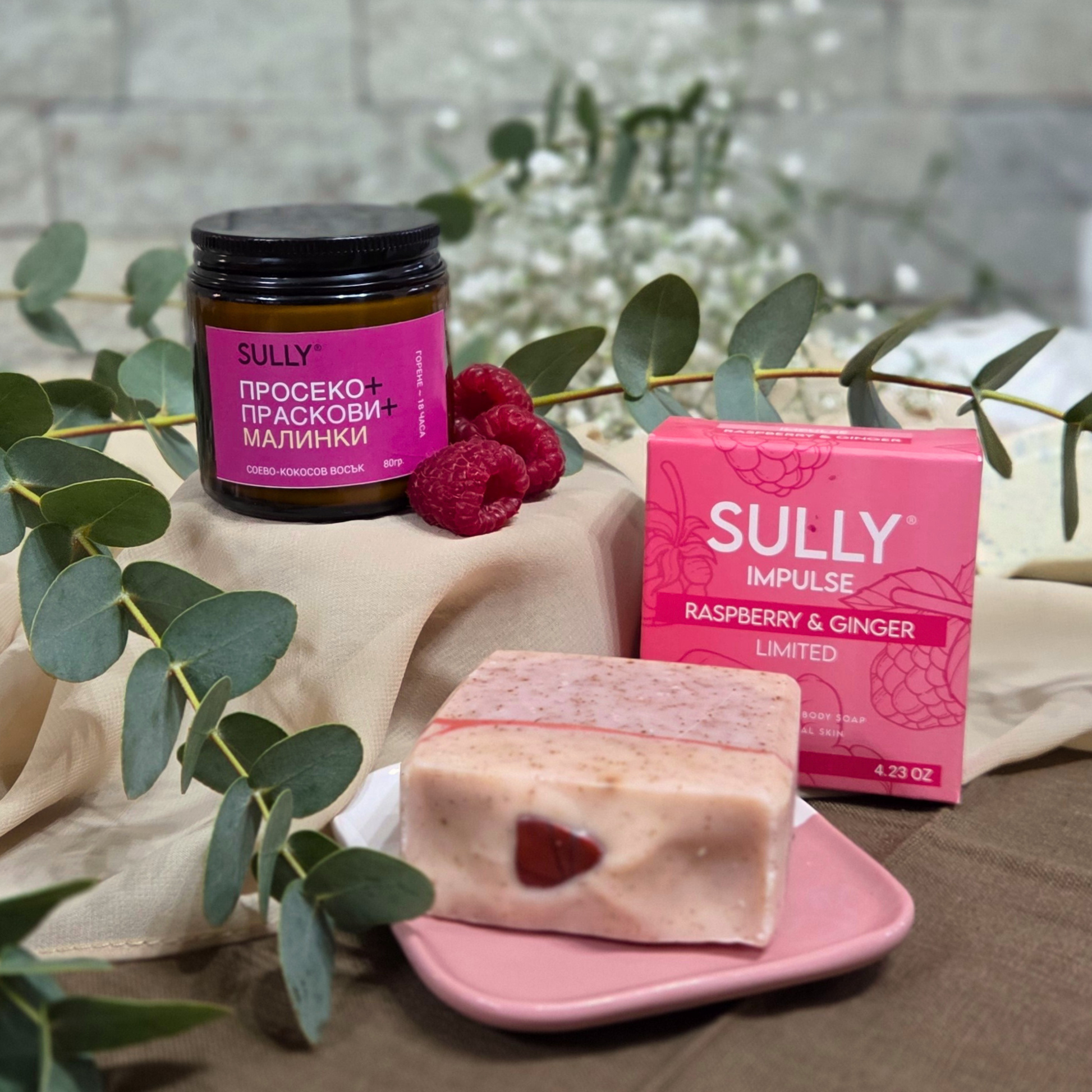 Комплект „Душ и аромат“ с кристален сапун IMPULSE (малина и джинджифил), розова керамична сапунерка и соева свещ „Просеко, праскови и малинки“, с малини и евкалипт като акцент на фон.