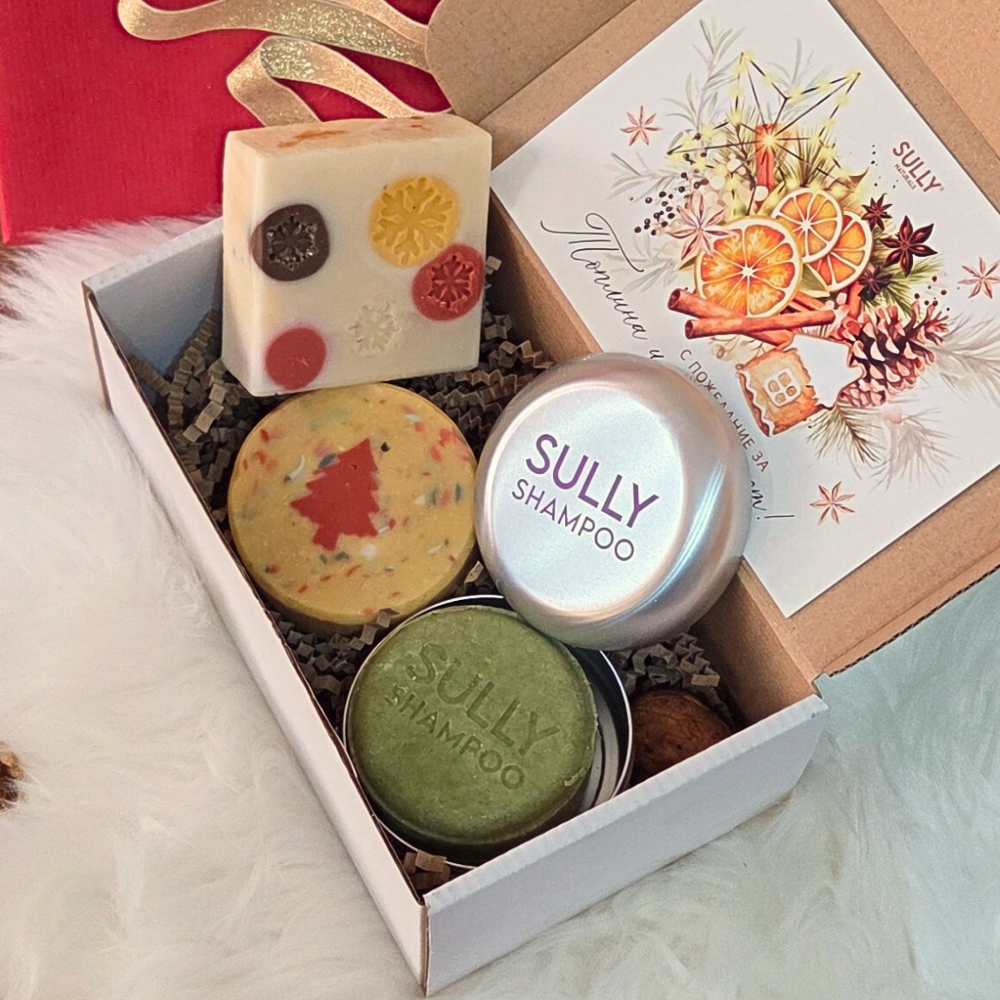 Празничен комплект „Ритуал за коса и тяло“ SULLY Naturals с шампоан, метална кутийка и ароматни сапуни с коледни мотиви.