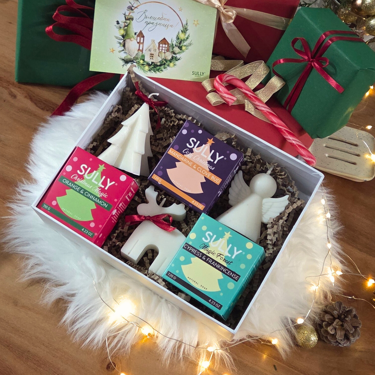 Коледен комплект „Ароматна Коледа“ SULLY Naturals с три сапуна, три ароматни свещи фигурки и керамична сапунерка в празнична кутия.