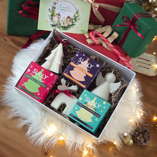 Коледен комплект „Ароматна Коледа“ SULLY Naturals с три сапуна, три ароматни свещи фигурки и керамична сапунерка в празнична кутия.