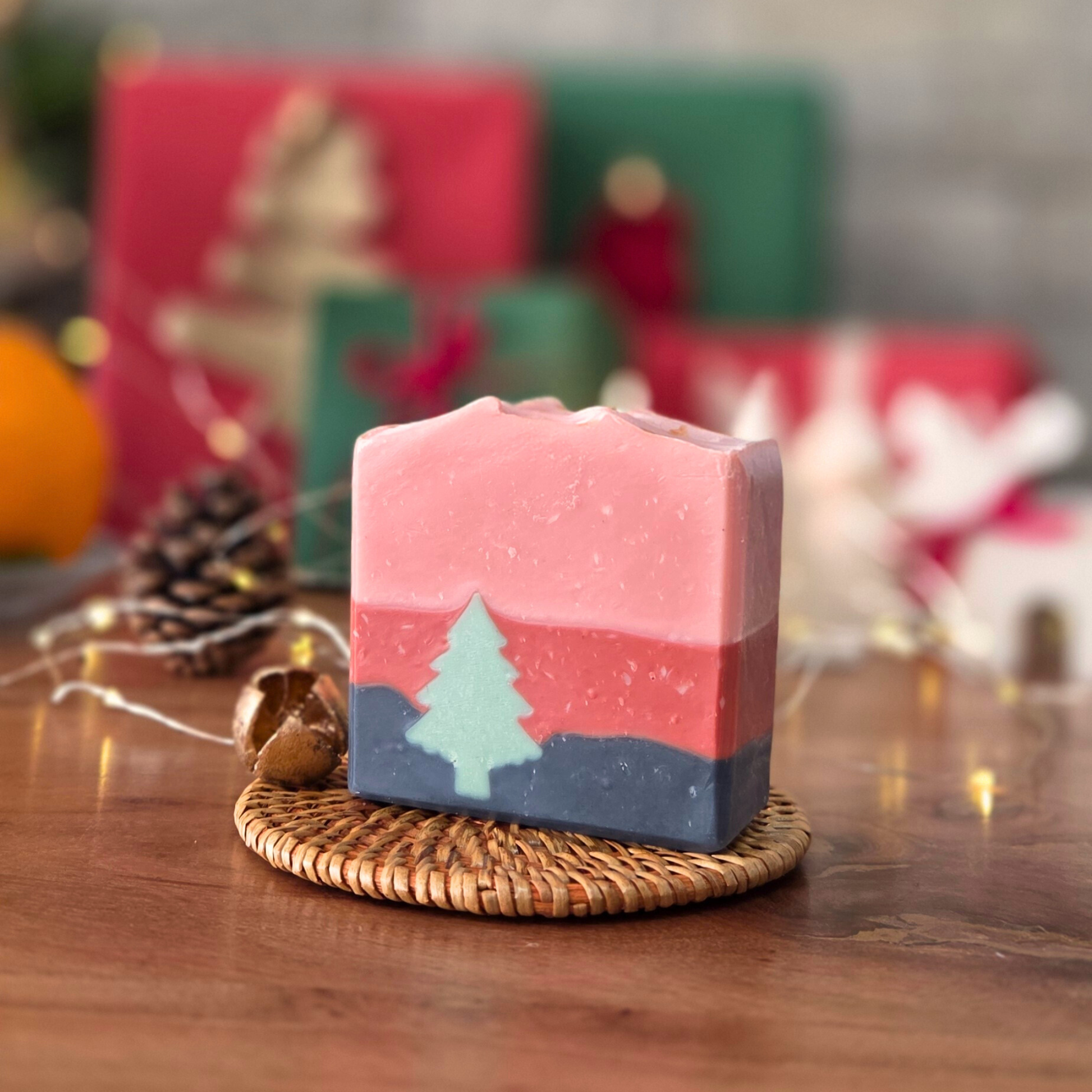 Натурален сапун „Горско вълшебство“ SULLY Naturals с кипарис и тамян, върху ратанова подложка и празничен фон.