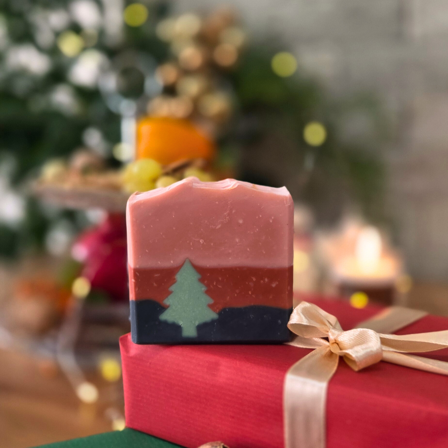 Ароматен сапун „Горско вълшебство“ SULLY Naturals с цветни слоеве и елхичка, сред празнична украса и естествени елементи.