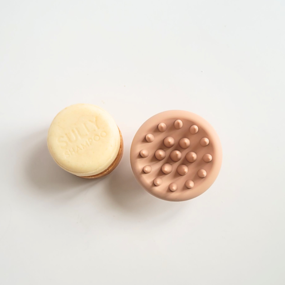 Твърд шампоан SULLY и силиконов масажор за скалп, поглед отгоре върху светъл фон