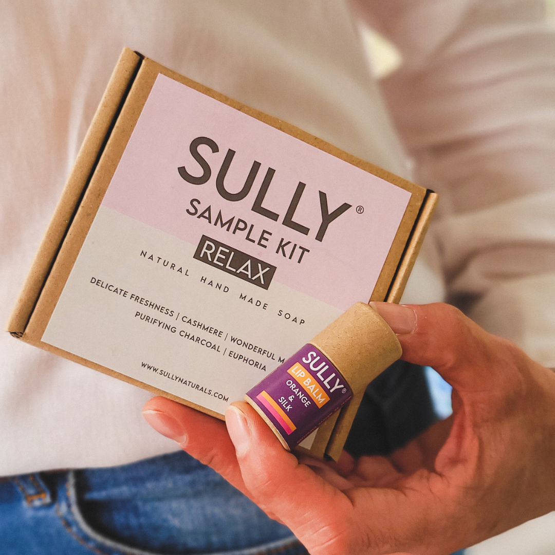 SULLY Sample Kit Relax с мини сапуни и мини балсам за устни 6 г, държани в ръка.