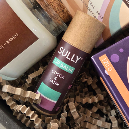 Балсам за устни Cocoa & Satin от комплекта „Сутрешен уют“ SULLY Naturals, заснет отблизо с натурална опаковка.